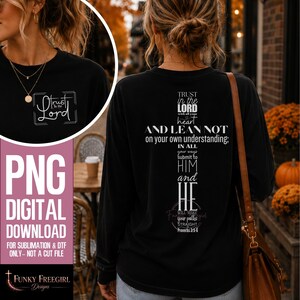May include: A black long-sleeve shirt featuring white text on the back arranged in the shape of a cross, reading Trust in the Lord with all your heart and lean not on your own understanding; in all your ways submit to him and he will make your paths straight, Proverbs 3:5-6. A smaller version of the text is on the front.