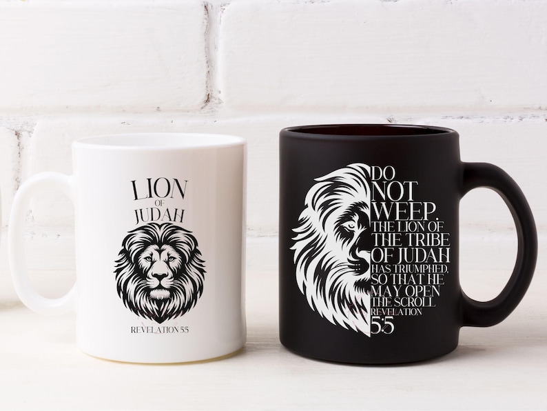May include: Two ceramic mugs, one white and one black, each featuring a lion's head design. The white mug has the text "LION OF JUDAH" and "REVELATION 55". The black mug has the text "DO NOT WEEP. THE LION OF THE TRIBE OF JUDAH HAS TRIUMPHED. SO THAT HE MAY OPEN THE SCROLL REVELATION 55."