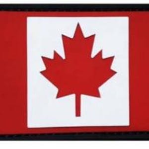 May include: A red rectangular patch with a white maple leaf in the center. The patch has a black border.