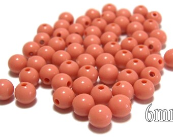 May include: A pile of 6mm round, coral-colored plastic beads.