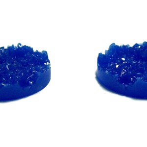 May include: Two blue resin round bases with a textured, crystal-like surface. The bases are ideal for miniature gaming.