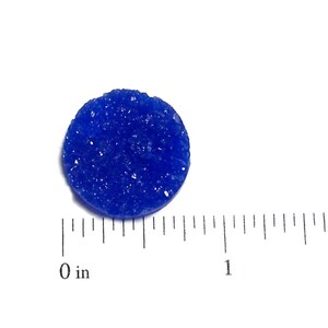 May include: A small, round, blue, textured disc. The disc is about 1 inch in diameter.