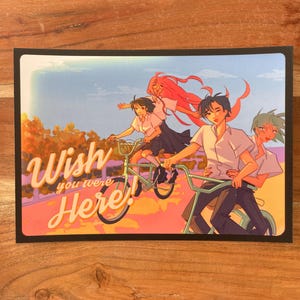 May include: A vintage-style postcard with a colorful illustration of four friends riding bicycles. The text "Wish you were Here!" is written in a retro font.