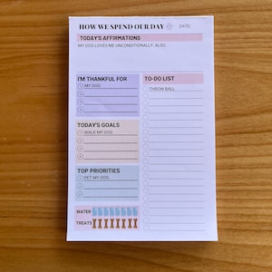 May include: A white printable notepad with a paw print and the text "How We Spend Our Day". The notepad has sections for "Today's Affirmations", "I'm Thankful For", "Today's Goals", "Top Priorities", "To-Do List", "Water", and "Treats".