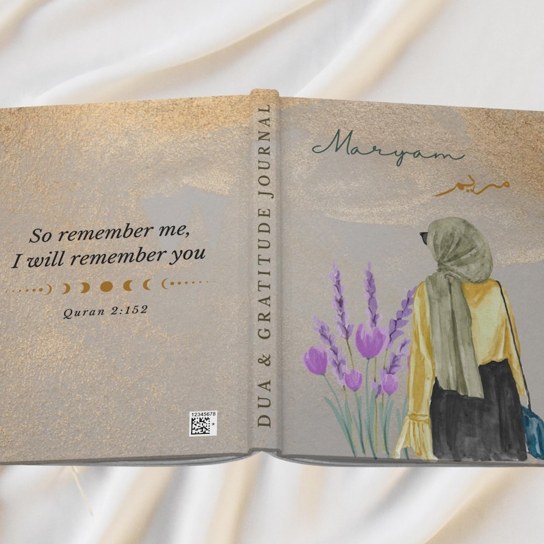 May include: Open journal with a gold and gray cover. The left side has the text "So remember me, I will remember you" and "Quran 2:152". The right side features an illustration of a person in a hijab, lavender flowers, and the name "Maryam".