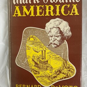 May include: A brown book cover with the title "Mark Twain's America" in yellow letters. The cover features an illustration of Mark Twain with a cigar in his mouth, looking at a scene of a steamboat on a river with a sunset in the background.