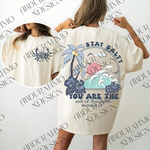 a woman wearing a white robe with a palm tree on it