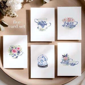 May include: Set of five cards featuring watercolor illustrations of blue and white teacups and saucers with floral arrangements. The cards are blank and perfect for sending a handwritten note.