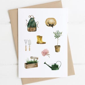 May include: A set of watercolor illustrations of gardening tools and supplies, including a green apron, a straw hat, yellow rain boots, a trowel, a garden fork, a potted olive tree, a watering can, a wooden planter with herbs, and a pink flower.