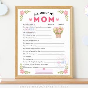 May include: A framed "All About My Mom" printable worksheet with fill-in-the-blank prompts. The design features pink floral accents, hearts, and a watercolor illustration of flowers in a basket. The text includes "Download and Print" and "Design to Create to Inspire."