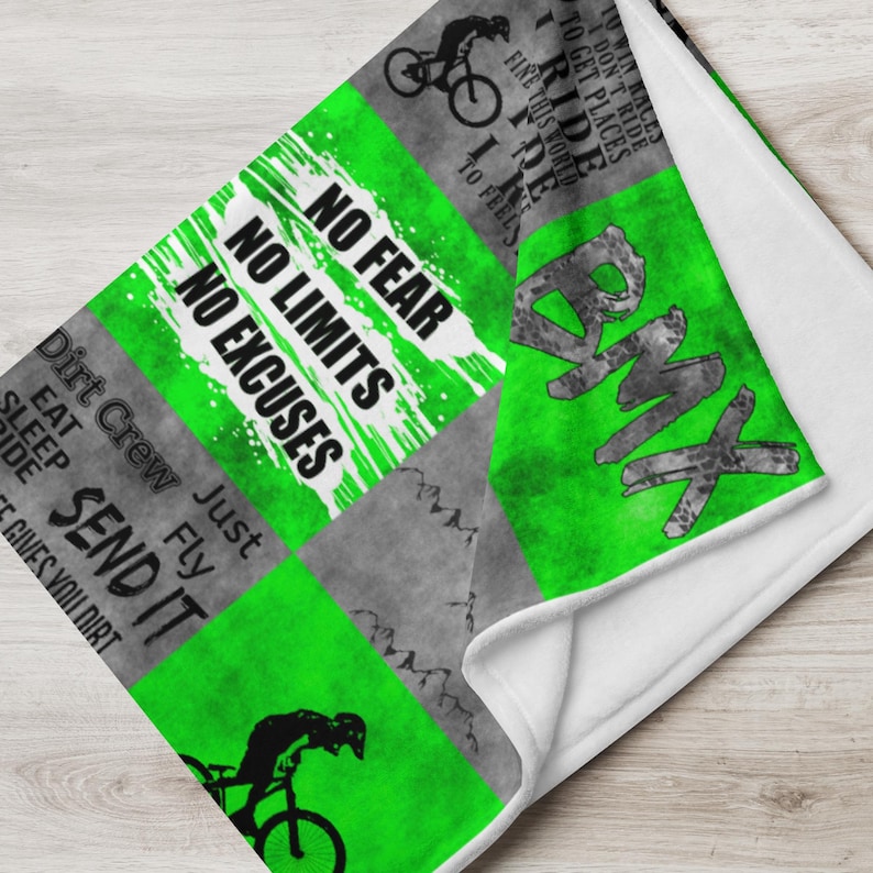 K&ouml;nnte beinhalten: Gr&uuml;n-graue Fleece-Decke mit einem BMX-Fahrrad-Design. Die Decke zeigt den Text "No Fear, No Limits, No Excuses" und "Dirt Crew Just Fly Send It".