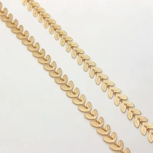Könnte beinhalten: Zwei Stränge goldene Blattketten mit einem zarten Blattmuster.