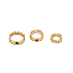 Op de afbeelding: Drie gouden springringen in verschillende maten. De ringen zijn gemaakt van metaal en hebben een gladde, gepolijste afwerking.