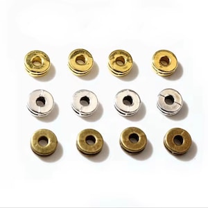 以下が含まれることがあります： 金、銀、ブロンズの3色でできた丸い金属ビーズが12個あります。ビーズの中央には穴があり、4つずつ3列に並んでいます。