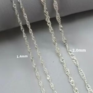 Op de afbeelding: Vier zilveren kettingen in verschillende diktes, gelabeld 1,4 mm en 2,0 mm. De kettingen liggen in een rij, met de dikste ketting rechts en de dunste ketting links.