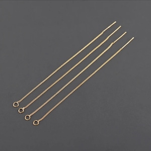 May include: Four gold chain earring extenders with jump rings. The extenders are approximately 5 cm long.
