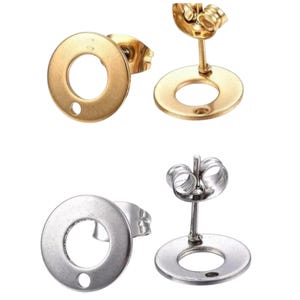 Puede incluir: Un par de pendientes simples de círculo en oro y plata. Los pendientes están hechos de acero inoxidable y tienen un acabado liso y pulido.