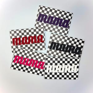 May include: A collection of rectangular coasters with a black and white chequered design. Each coaster displays the word "mama" in various colours: purple, red, black, pink, and white. The coasters are set against a white backdrop.
