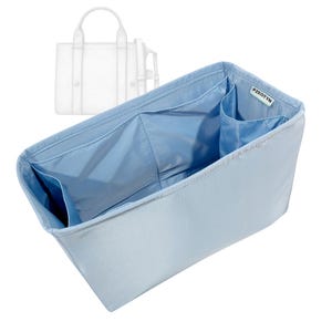 May include: A pale blue handbag organiser with several pockets. The organiser is designed to fit inside a tote bag, with a label that reads "PZEOTYN". The organiser is made of a smooth, pale blue fabric.