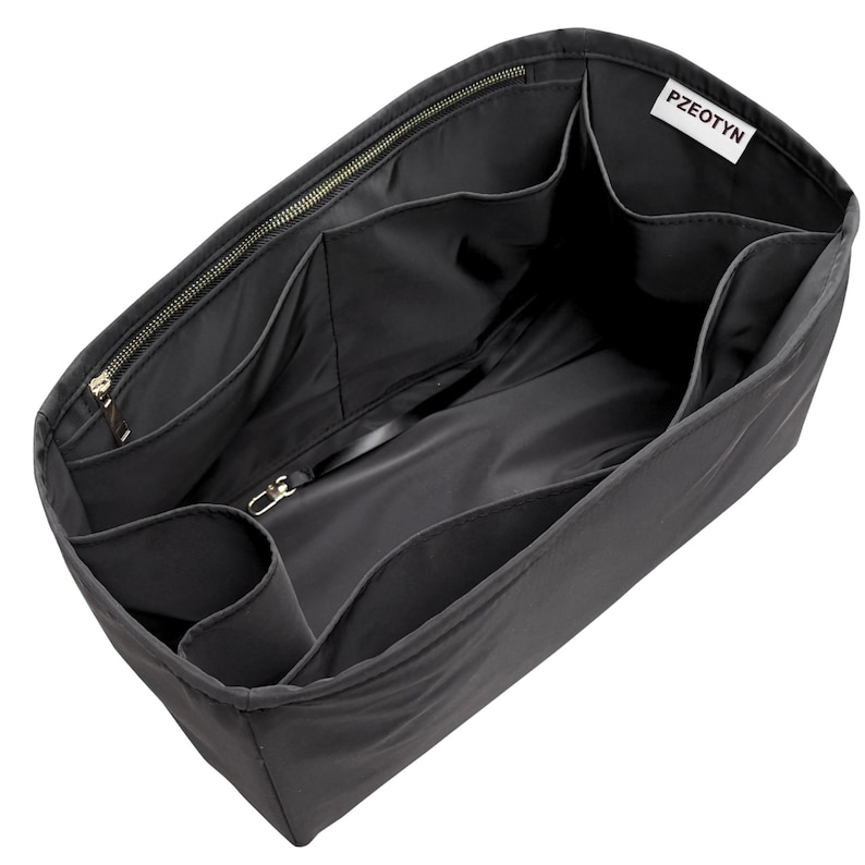 May include: Black handbag organizer with multiple compartments and a zippered top. Features a label that reads "PZEOTYN". The organizer is designed to keep items neatly arranged inside a larger bag.