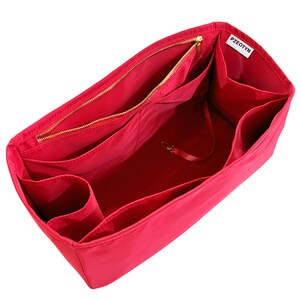 May include: A bright red handbag organizer with multiple compartments and a zippered closure. The interior features various pockets and a small strap with a clasp. The brand name "PZEOTYN" is visible on a white tag.