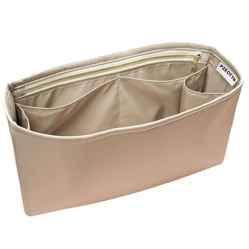 May include: Beige handbag organizer with multiple compartments and a zippered top. The organizer has a rectangular shape and is made of a smooth, neutral-toned material. The brand name "PZEOTYN" is visible on a small tag.