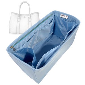 Pode incluir: Um organizador de bolsa azul claro com vários bolsos e fecho de correr. O organizador foi concebido para caber dentro de uma mala tote, com um contorno branco de uma mala tote no fundo. A marca "PZEOTYN" é visível.