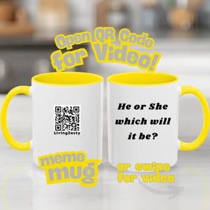 May include: Two white ceramic mugs with yellow handles and interiors. One mug has a QR code and the text "LivingZesty". The other mug has the text "He or She which will it be?". The mugs have the text "Open QR Code for Video!" and "meme mug".