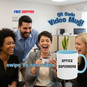 May include: A white mug with a light blue interior and handle, featuring the text "OFFICE SUPERHERO" in black. The image shows a group of people laughing, with the words "QR Code Video Mug!" and "swipe to see video".
