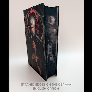 May include: A hardcover book with a dark, gothic-style cover featuring a pale-skinned figure with white hair and a woman. The spine shows a castle under a full moon. The text at the bottom reads "Sprayed edges on the German English option."