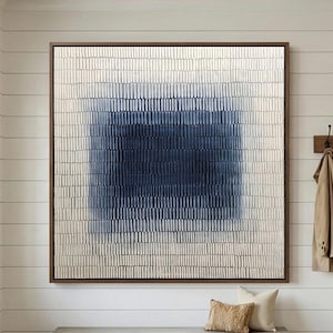 May include: A large square wall art piece featuring a textured pattern of vertical white dashes surrounding a central deep blue rectangular block. The artwork is framed in a thin dark wood border and hangs on a white horizontal paneled wall.