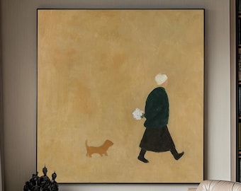 May include: An abstract painting depicts a person walking a dog. The person is wearing a dark green jacket and black skirt, holding flowers. The painting hangs above a black cabinet, with a leather chair and ottoman in the foreground.