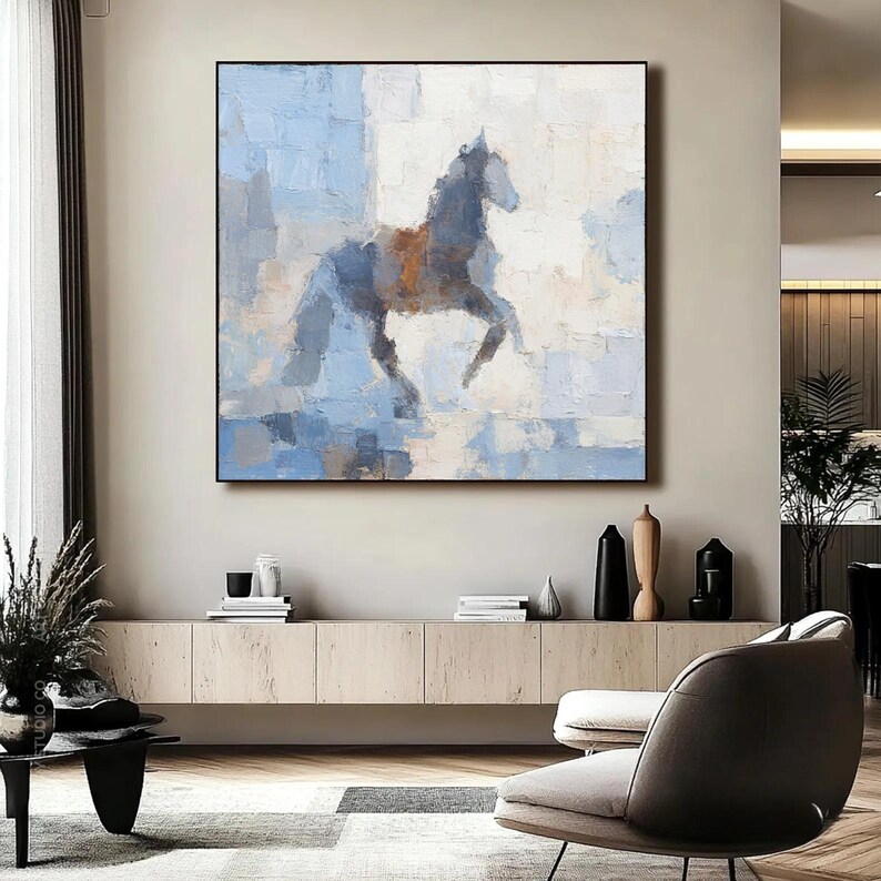 May include: Abstract oil painting of a horse in motion. The artwork features a dark grey horse with a brown saddle against a backdrop of blue and white brushstrokes. The painting is framed in a black square.