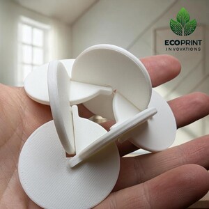 May include: A collection of white, 3D-printed interlocking puzzle pieces. The pieces are held in a hand, showcasing their circular and curved shapes. The logo "ECOPRINT INOVATIONS" is visible in the upper right corner.