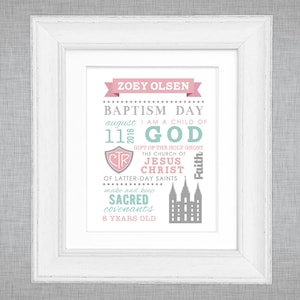 May include: A white framed print with a pink and teal design. The text reads "ZOEY OLSEN BAPTISM DAY august 11 2016 I AM A CHILD OF GOD GIFT OF THE HOLY GHOST THE CHURCH OF JESUS CHRIST OF LATTER-DAY SAINTS make and keep SACRED covenants 8 YEARS OLD".