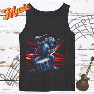 May include: Black tank top featuring a blue monkey playing a drum with drumsticks. The monkey is set against a backdrop of red lines. The word "Music" is written in yellow script at the top left.