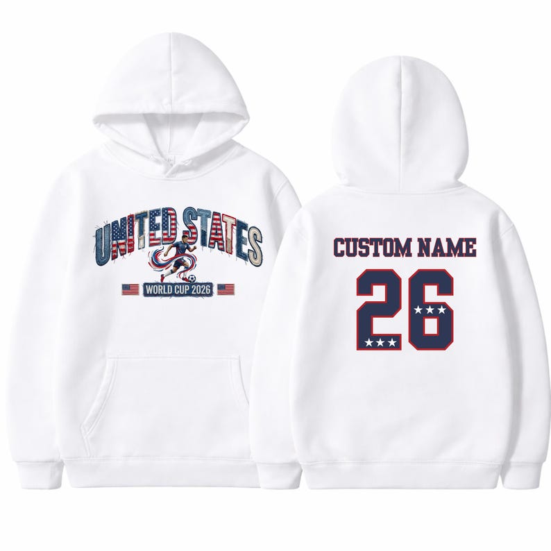 Peut inclure: Sweat-shirt &agrave; capuche blanc avec l'inscription "UNITED STATES WORLD CUP 2026" sur le devant. Le dos pr&eacute;sente "CUSTOM NAME" au-dessus du num&eacute;ro "26" avec trois &eacute;toiles. Le design incorpore les couleurs rouge, blanc et bleu.