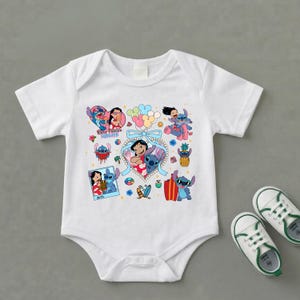 May include: A white short-sleeved baby bodysuit featuring a colorful graphic print of Lilo and Stitch characters, including balloons, a pineapple, a surfboard, and the text Best Friends Forever, accompanied by a pair of white sneakers with green trim.