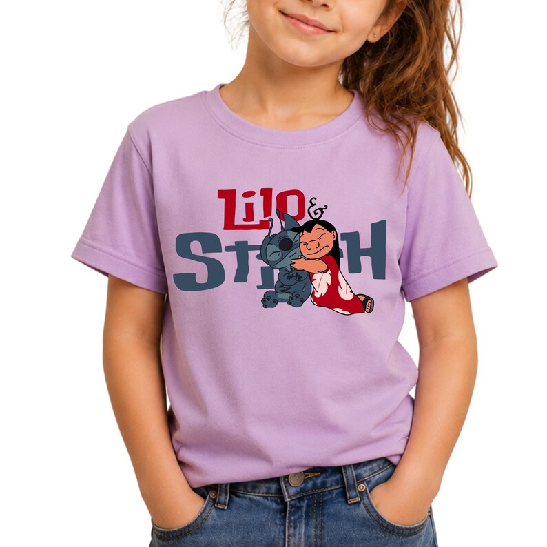 K&ouml;nnte beinhalten: Ein hellviolettes Kurzarm-T-Shirt mit einer Grafik der sich umarmenden Figuren Lilo und Stitch. Der Schriftzug Lilo & Stitch ist in Rot und Dunkelblau auf der Brust aufgedruckt. Das T-Shirt hat einen Rundhalsausschnitt und eine Standardpassform.
