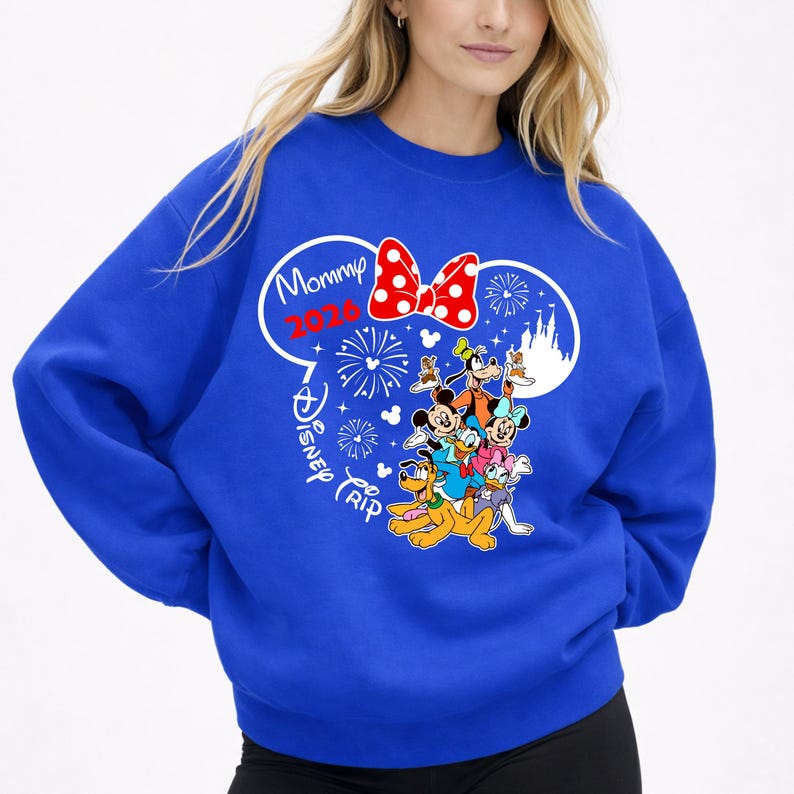 May include: Royal blue sweatshirt featuring a graphic of Disney characters, including Mickey Mouse, Minnie Mouse, and Goofy. The design includes a red polka dot bow, fireworks, and the text "Mommy 2020 Disney Trip."