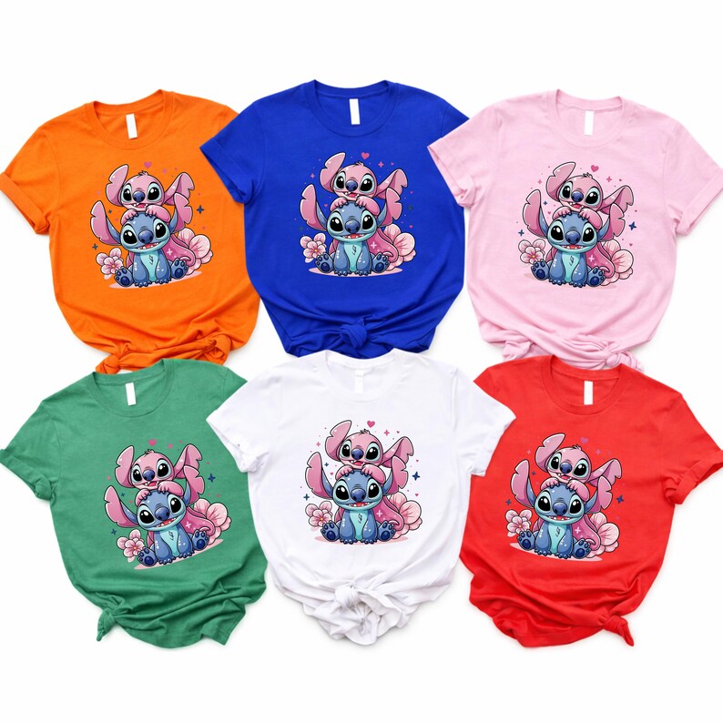 Pode incluir: Seis camisetas de manga curta em v&aacute;rias cores: laranja, azul, rosa, verde, branco e vermelho. Cada camisa apresenta uma ilustra&ccedil;&atilde;o de desenho animado de dois personagens, um azul e outro rosa, com flores.