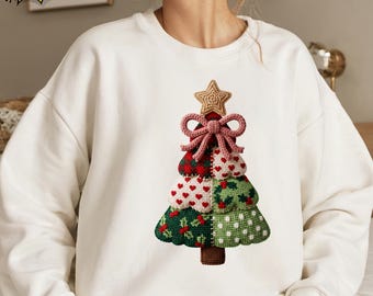 May include: White sweatshirt featuring a colorful Christmas tree design. The tree is composed of various patterns, including hearts, polka dots, and holly, topped with a star and bow. The text "SHIP NEXT DAY" is in a yellow banner.