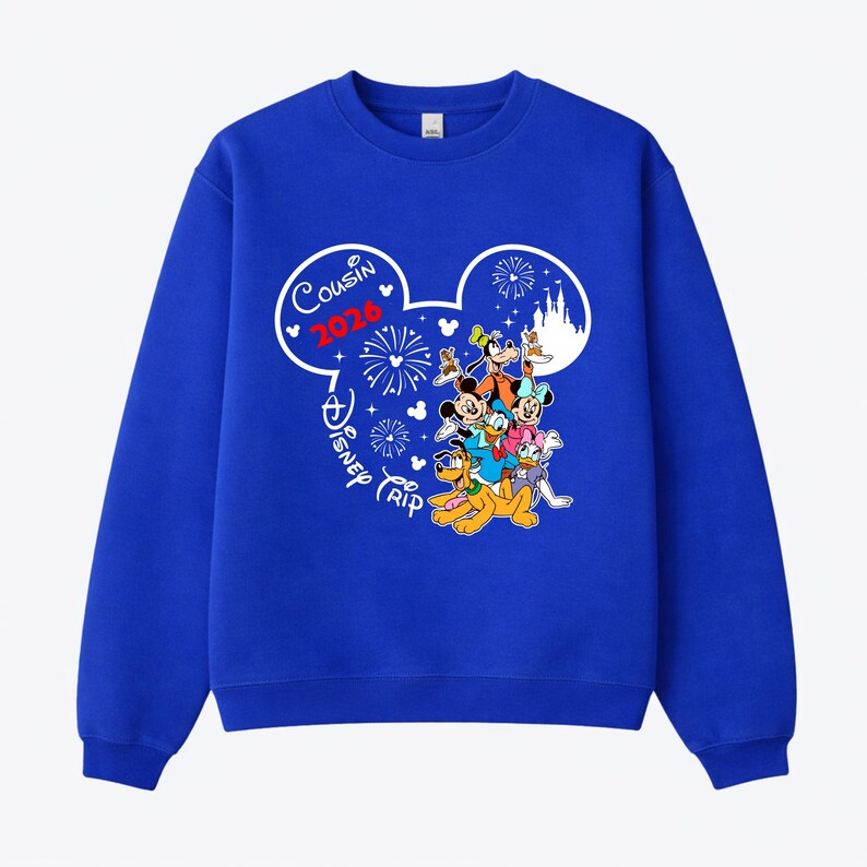 May include: Royal blue sweatshirt featuring a graphic of Mickey Mouse and friends. The design includes the text "Cousin 2026" and "Disney Trip" in a white Mickey Mouse head shape, with fireworks and a castle.