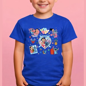 May include: A royal blue short-sleeved t-shirt featuring a colorful graphic print of Lilo and Stitch characters. The design includes multiple illustrations of the pair, a heart-shaped frame with a bow, balloons, a pineapple, and surfboards.