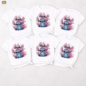 Pode incluir: Seis camisetas brancas com uma ilustra&ccedil;&atilde;o de desenho animado de um personagem alien&iacute;gena azul e rosa. O design mostra os personagens sentados em flores cor-de-rosa. As camisas t&ecirc;m mangas curtas e gola redonda.