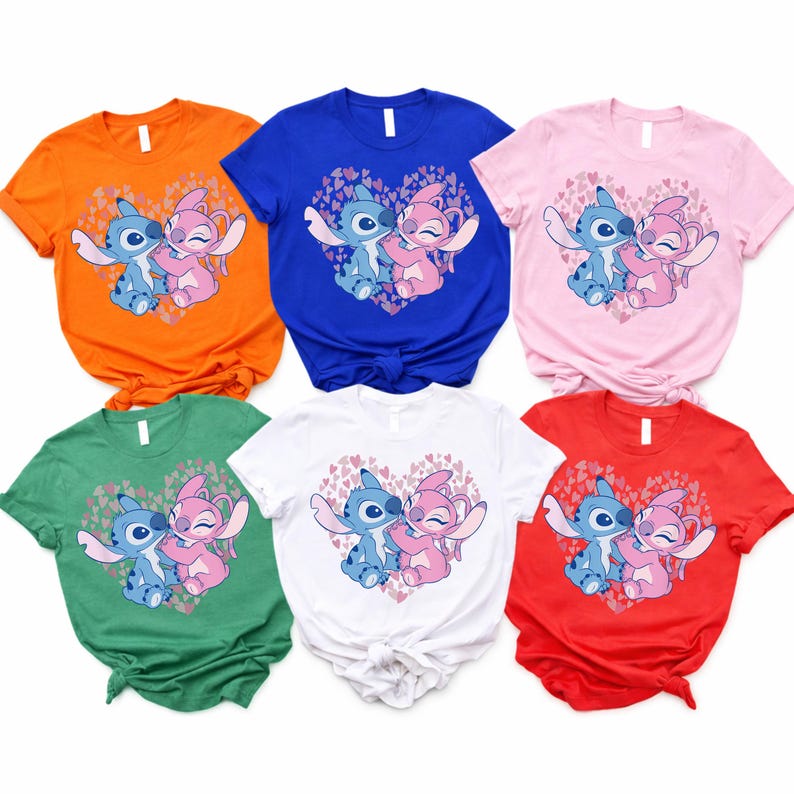 以下が含まれることがあります： オレンジ、青、ピンク、緑、白、赤の6色の半袖Tシャツ。各シャツには、ハート型のデザインの中で抱き合う2人の漫画のキャラクターのグラフィックが描かれています。キャラクターは青とピンクです。