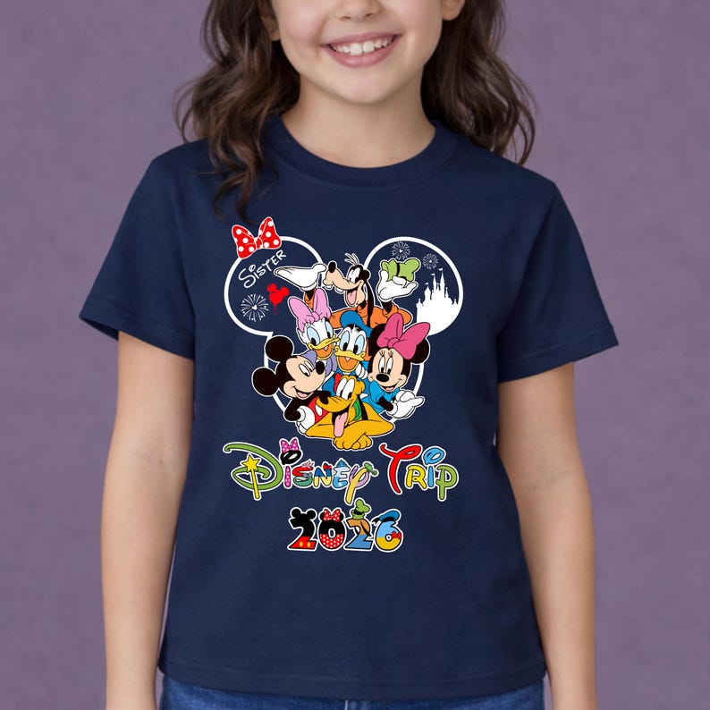 May include: A navy blue t-shirt with a vibrant Disney character design, including Mickey and Minnie Mouse, Donald Duck, and Goofy. The shirt displays "Disney Trip 2026" in a fun font, with the word "Sister" above the characters.