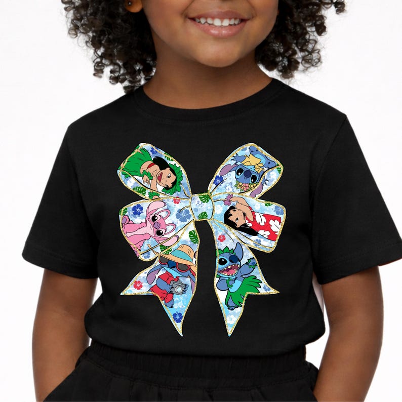 May include: Black t-shirt with a large bow design showcasing cartoon characters. The bow has a blue floral pattern with gold edging. The characters are in various poses and outfits, adding a playful touch to the shirt.
