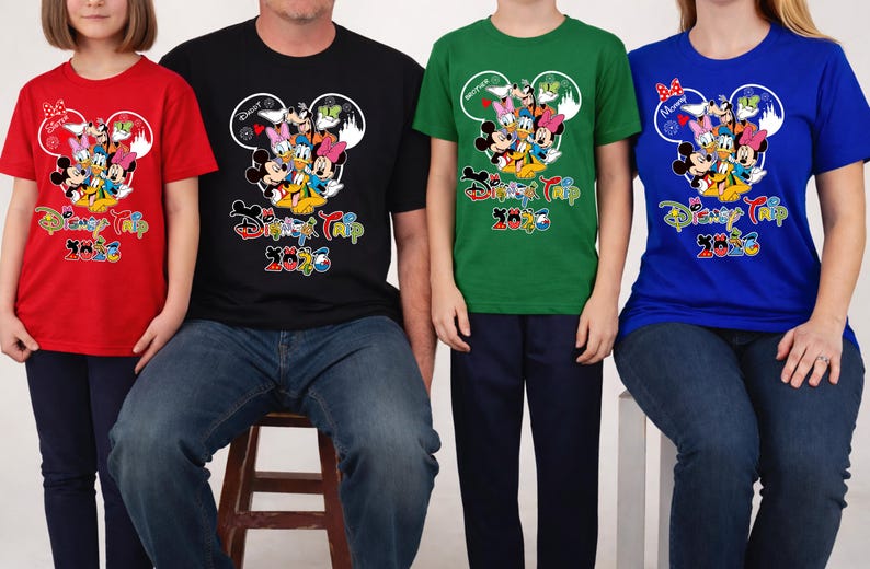 May include: Four people wearing matching t-shirts with a Disney theme. The shirts are red, black, green, and blue. Each shirt features a Mickey Mouse head design with Disney characters and the text "Disney Trip 2023".