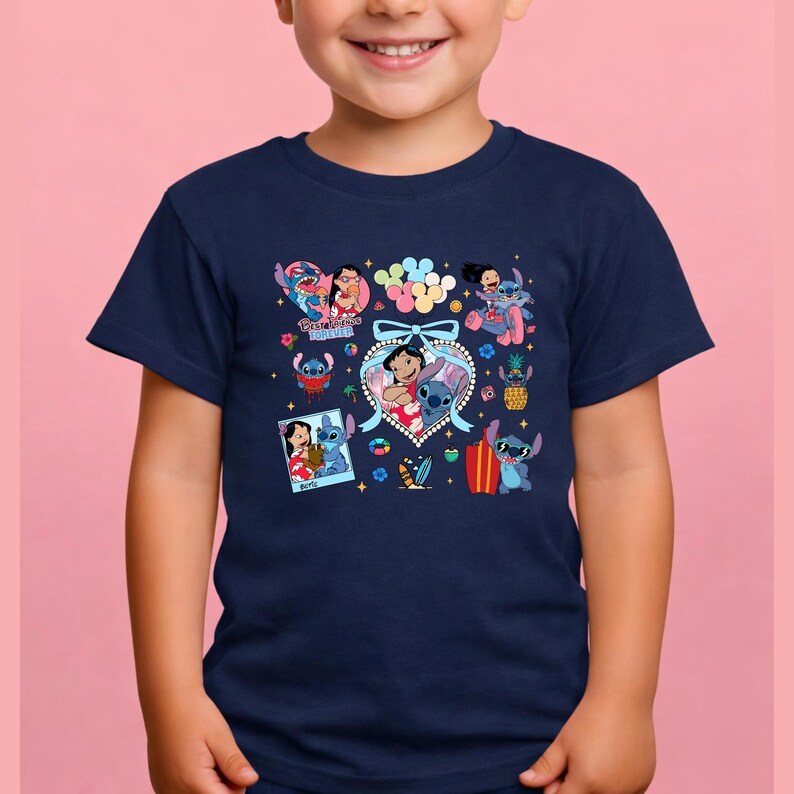 May include: A navy blue short-sleeve t-shirt featuring a colorful graphic print of Lilo and Stitch characters. The design includes multiple small illustrations, a central heart-shaped frame with a bow, and the text Best Friends Forever.